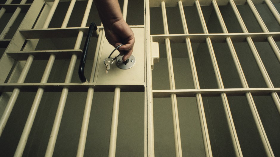 An officer locking a jail cell. GettyImages/Charles O'Rear
