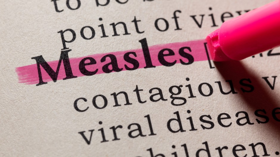 The word "measles" seen in a dictionary. GettyImages/Devonyu