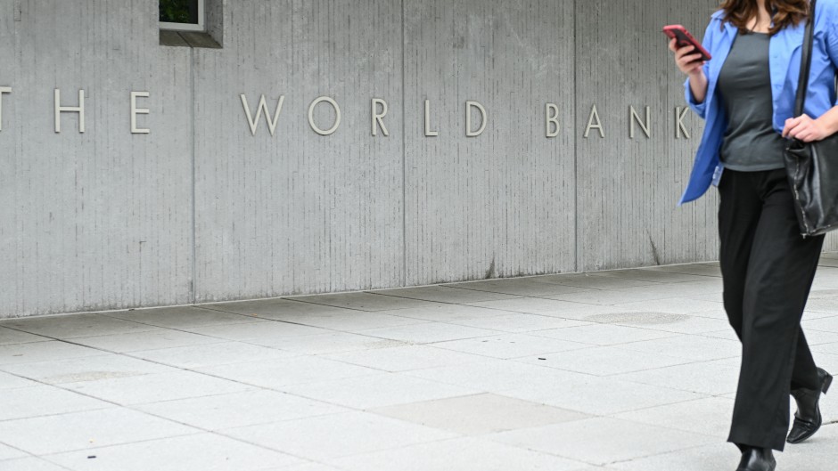 A woman walks by the World Bank headquarters in Washington. STR/NurPhoto via AFP