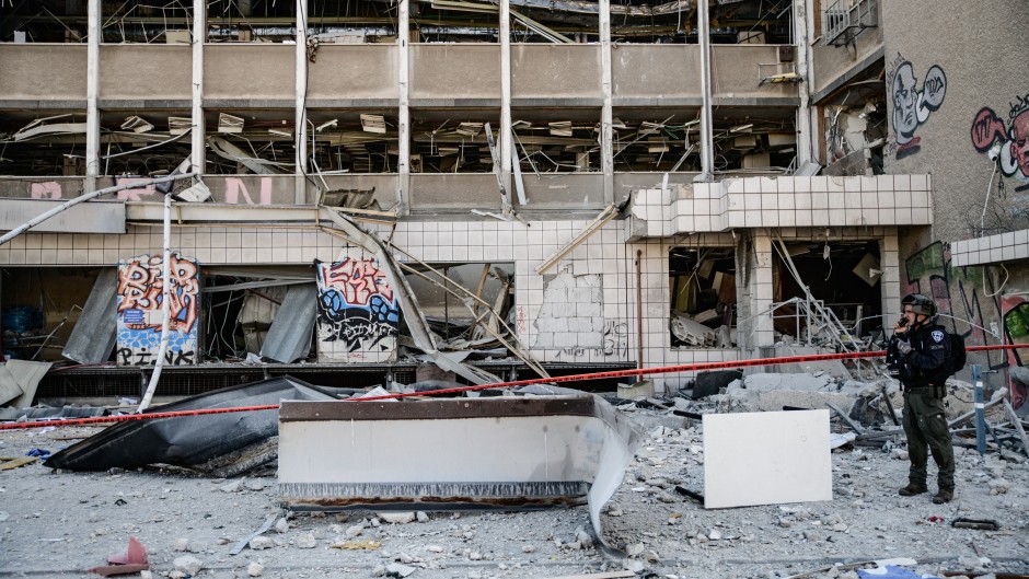 An Israeli police officer inspects the site where an Iranian ballistic missile reportedly struck in Haifa, Israel. Matan Golan/Middle East Images via AFP