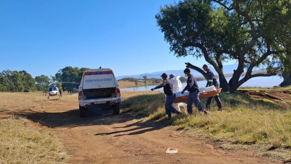 Police (SAPS) and forensic services carry a body of a flood victim to a vehicle in Mthatha - Eastern Cape floods