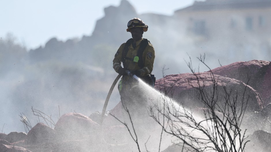  A firefighter sprays water near Perris, California. Mario Tama/Getty Images/AFP