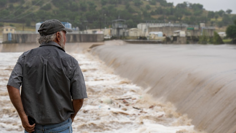 A Kerrville resident watches the rising waters of the Guadalupe River. Eric Vryn/Getty Images/AFP