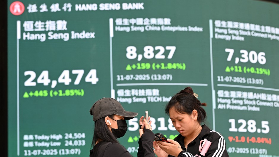 Women in front of an electronic sign board showing the Hang Seng Index in Hong Kong. AFP/Peter Parks