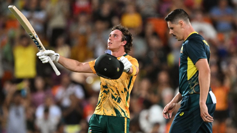 South Africa's batsman Dewald Brevis (L) celebrates scoring his century as Australia's bowler Ben Dwarshuis (R) looks on during the second Twenty20 international cricket match between Australia and South Africa in Darwin on August 12, 2025.