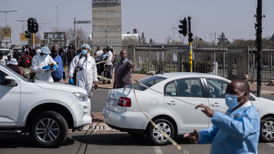 Forensic Police stands around a crime scene at the Maponya Mall in Soweto.