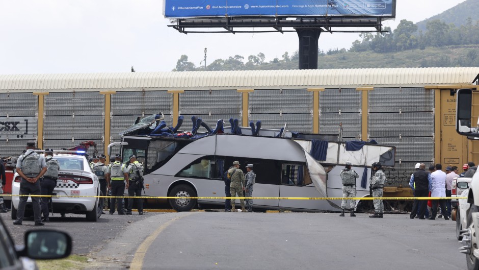 National guard members stand next to the wreckage of a passenger bus involved in an accident with a train. AFP/Ramses Vlades