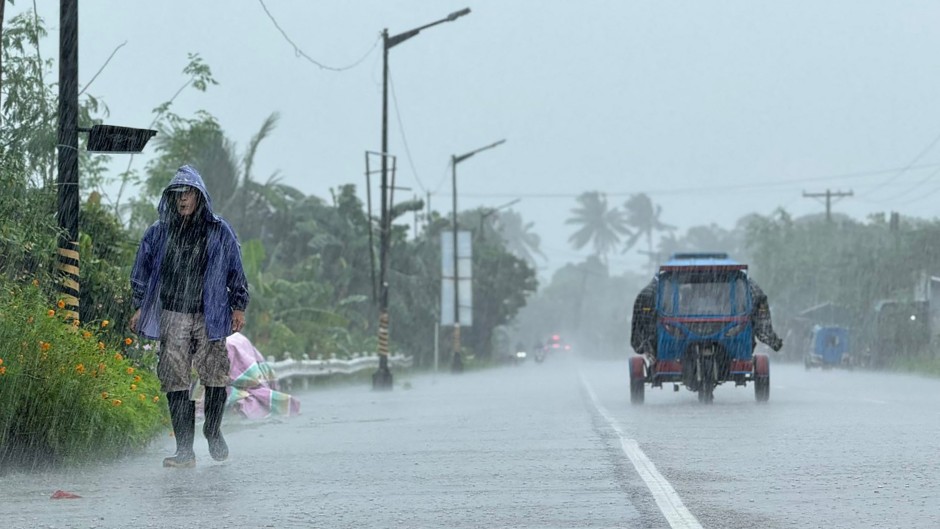 A man walks along a road amid heavy rain due to weather patterns from Super Typhoon Ragasa in Lal-lo town, Cagayan province. AFP/John Dimain