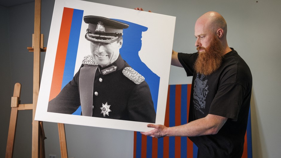 Pop artist Jacques Schneider carries an image of Grand Duke Henri of Luxembourg at his exhibition venue in Berchem. AFP/Simon Wohlfahrt
