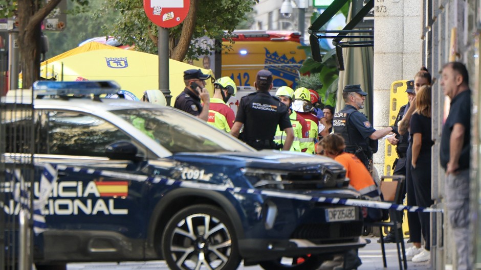 Police and emergency service workers are seen near the site of a collapsed building which was being refurbished in Madrid on October 7, 2025.