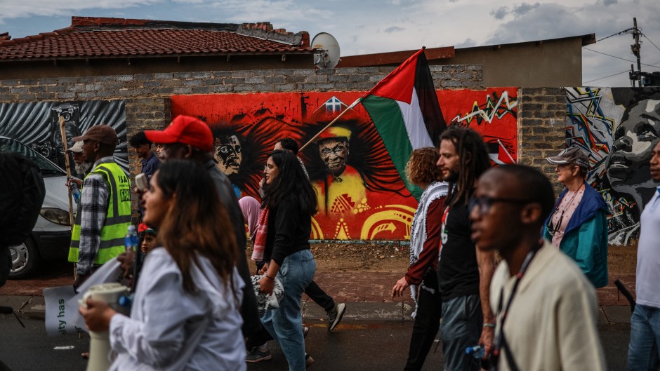 Protesters from South African Christians for Palestine and the Muslim community hold pro-Palestinian posters and flags during their march in Soweto 