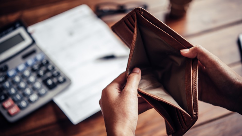 An empty wallet and calculator, budget. GettyImages/photobyphotoboy