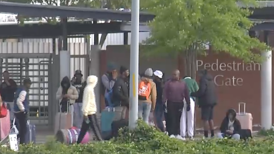 The stranded students sitting outside the gate.