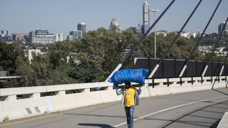 File: A man walks over a bridge connecting Alexandra to Sandton. AFP/Emmanuel Croset