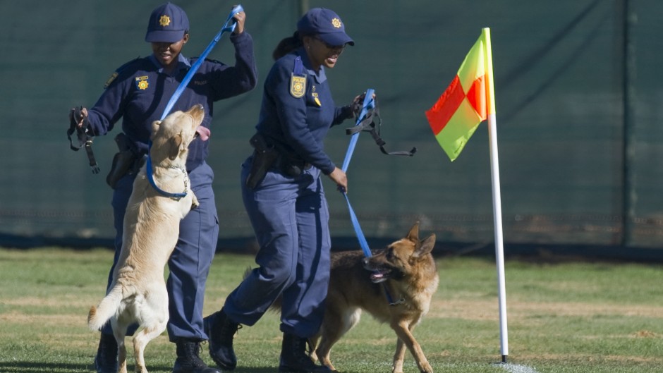 File: Police officers use trained dogs to check a field. AFP/Omar Torres