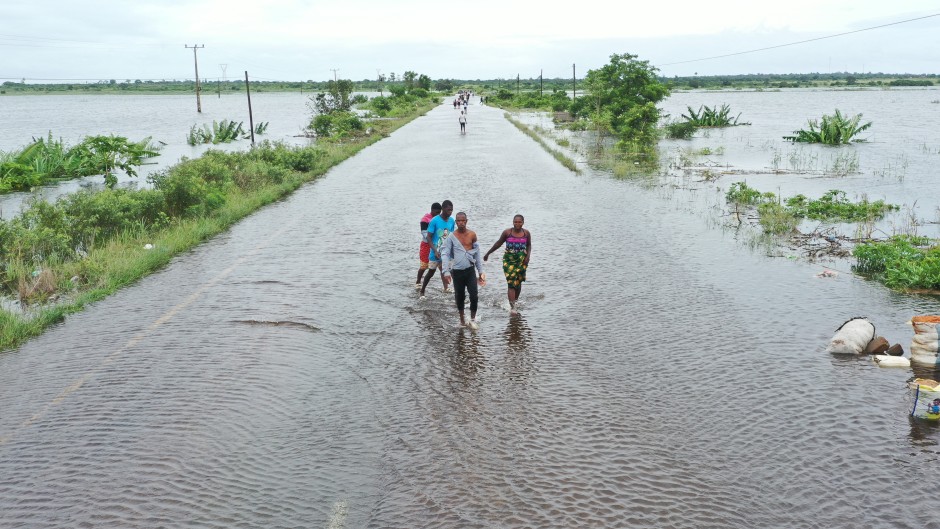Residents wading through floodwater to cross a road near Maputo. AFP/Emidio Jozine