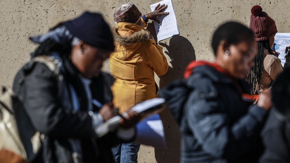 Unemployed people fill in the Department of Unemployment and Labour work seeking registration forms. AFP/Phill Magakoe