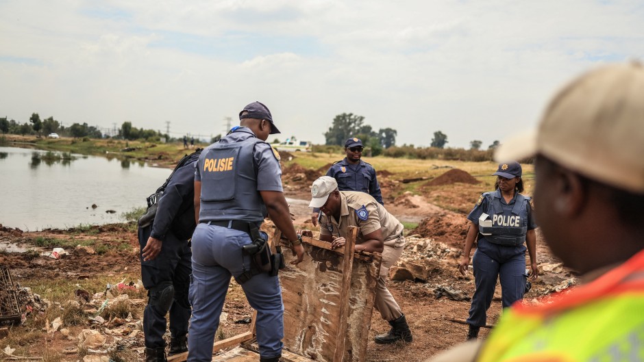 Police officers confiscate material used by artisanal miners from Gugulethu informal settlement. AFP/Phill Magakoe