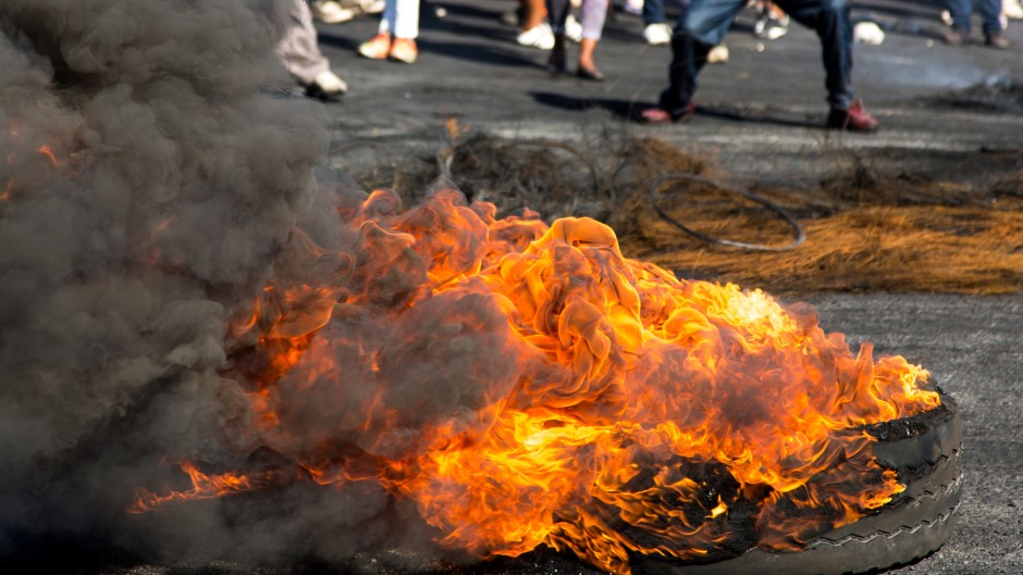 File: Protesters burning rubber tyres in the streets. GettyImages/FourOaks