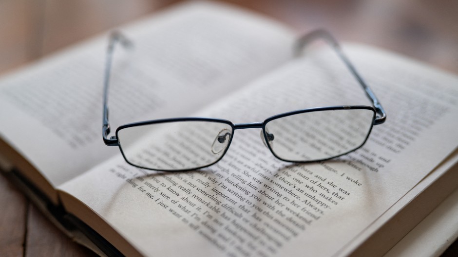 Reading glasses placed on an open book. Jean-Marc Barrère/Hans Lucas via AFP