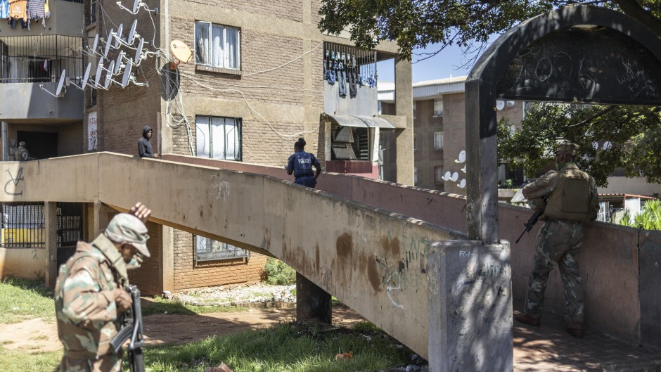 Police officers and soldiers search a building during a patrol operation in Westbury. AFP/Ilaria Finizio