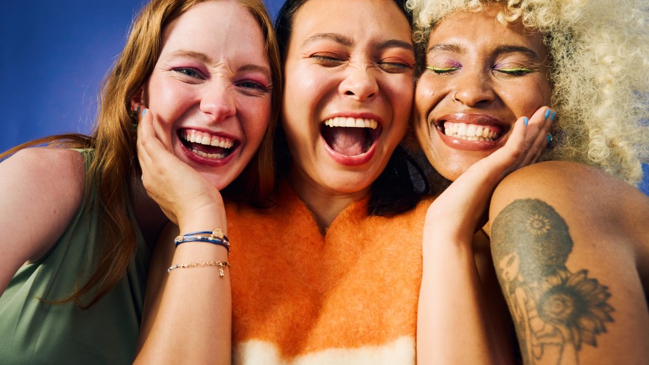 Three women laughing together. GettyImages/pixdeluxe