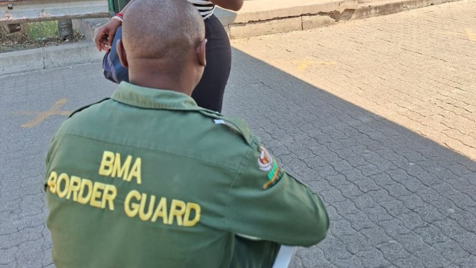 A border guard checking a woman's credentials. eNCA