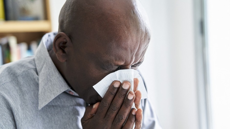 File: A man with a cold or flu blowing his nose. Frédéric Cirou/PhotoAlto via AFP