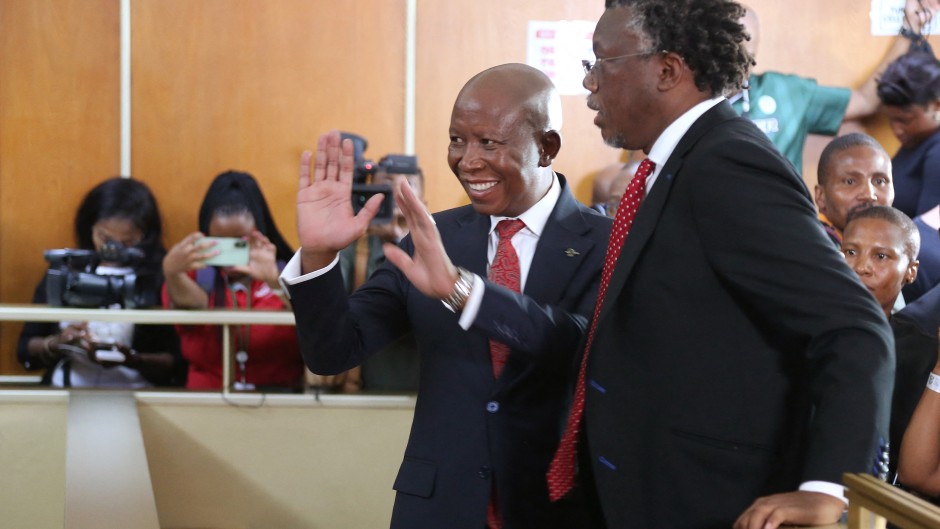 Economic Freedom Fighters (EFF) leader Julius Malema (CL) and a member of his legal team Tembeka Ngcukaitobi (CR) stand in the dock at the KuGompo City Regional court in East London on April 15, 2026 for his sentencing for firing an assault rifle at a rally eight years ago.