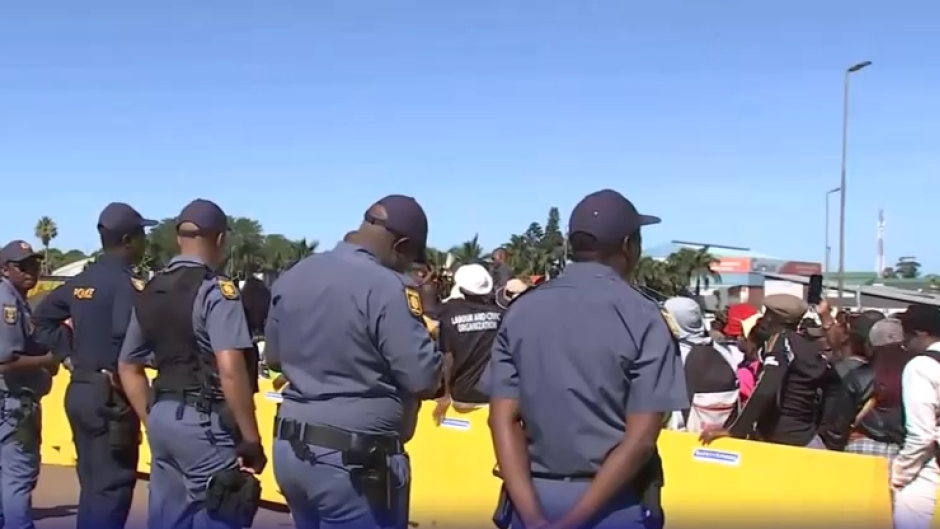 Police officers keeping an eye on demonstrators outside the Buthelezi Mall.