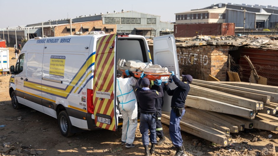 10 June_South African Police Service (SAPS) officers, along with forensic technicians, carry a victim’s body into a forensic pathology service vehicle at Jumpers informal settlement in Cleveland, east of Johannesburg, on June 10, 2026.