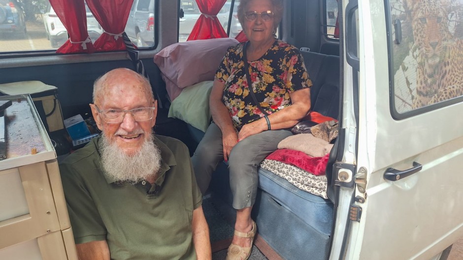 Elderly couple sitting in their Kombi that they use to travel throughout the Kruger national park