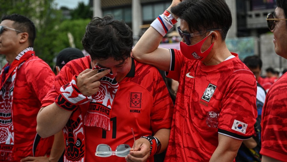 South Korean fans react after their team lost the 2026 World Cup football match against South Africa at Gwanghwamun Square in Seoul on June 25, 2026. (Photo by Jade GAO / AFP)