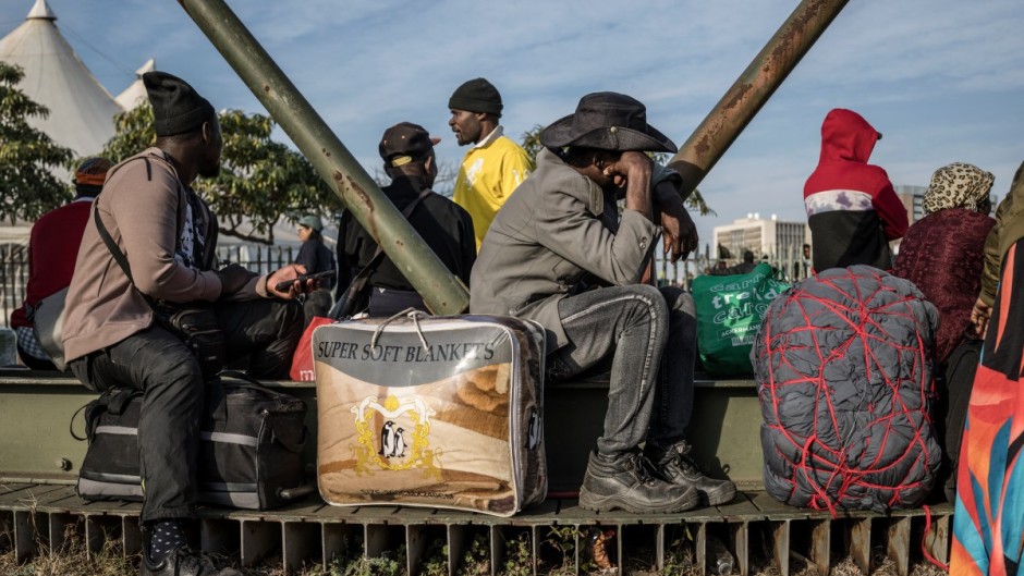 Undocumented migrants line up for transport to their home countries. AFP/Marco Longari