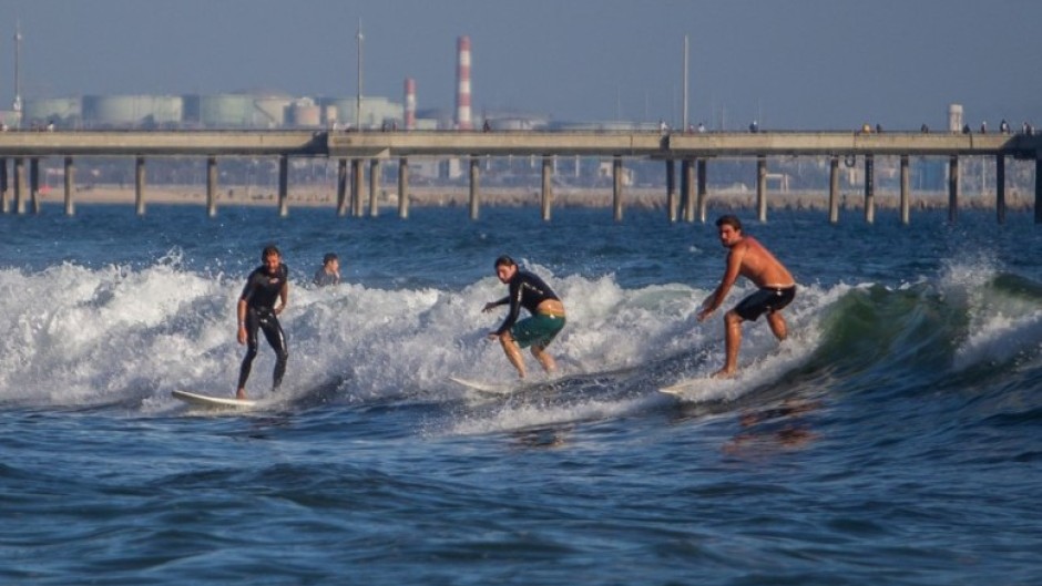 Surfers catch a wave at Venice Beach in Los Angeles, California. AFP/Apu Gomes