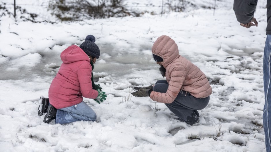 Children play with snow opposite Nottingham Road near Pietermaritzburg on 10 August. Photo by RAJESH JANTILAL / AFP