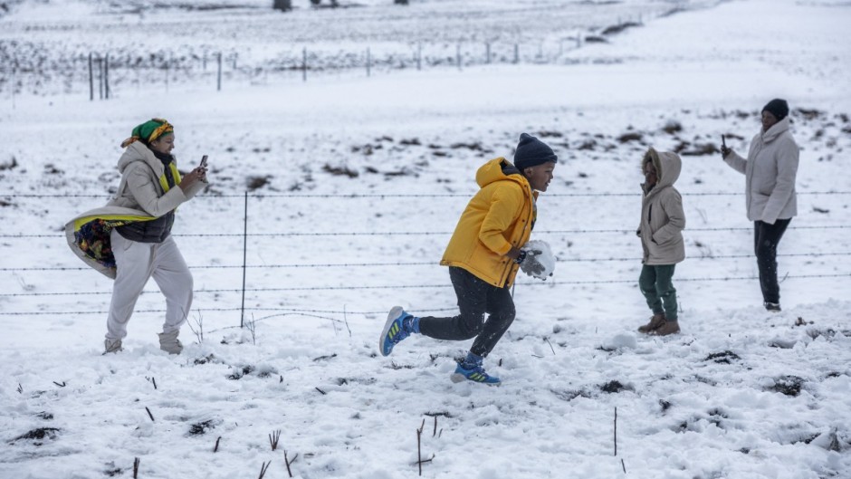 A family gathers to play in snow on Nottingham Road near Pietermaritzburg on 10 August. Photo by RAJESH JANTILAL / AFP