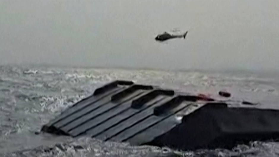 A helicopter circling the capsized ferry. AFP/UCG