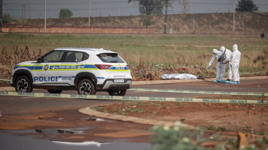 Members of the South African Police Service (SAPS) Forensic Pathology Services work on the crime scene where the body of a woman was discovered in Boksburg. AFP/Emmanuel Croset