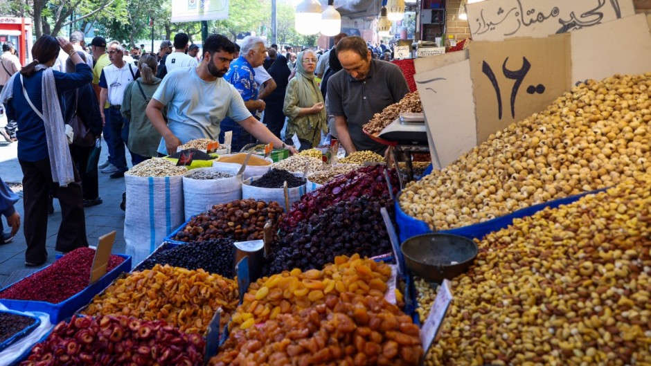 Shopkeepers arrange dried fruits and nuts in front of their shop at a market in Tehran. AFP