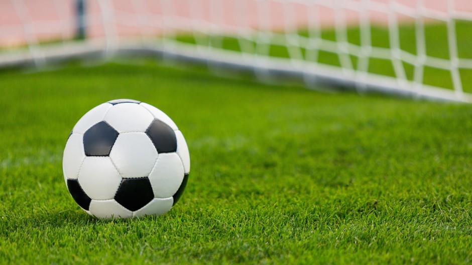 Closeup of a soccer ball and goalpost. GettyImages/artisteer