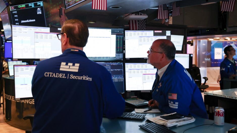 Traders work on the floor of the New York Stock Exchange (NYSE) at the opening bell. AFP/Timothy A. Clary