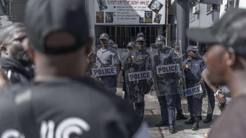 Members of the South African Police Service (SAPS) keep watch outside of the Department of Home Affairs Refugee Reception Centre on Che Guevara Road in Durban. AFP/Rajesh Jantilal
