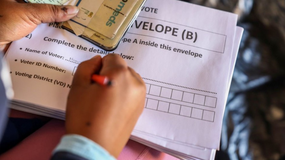 File: An IEC official assisting an elderly voter with a special vote. Gallo Images/Sharon Seretlo