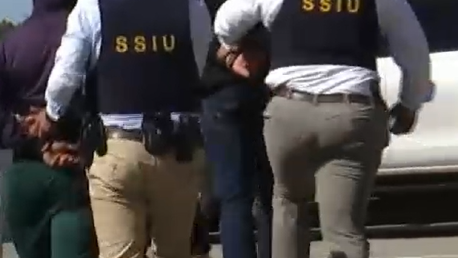 Two policeofficers of a special SWAT-unit of the Cape Town police take suspects away during a demonstration