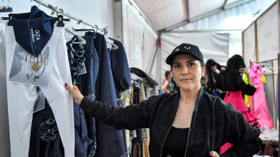 French fashion designer Maud Beneteau poses for a photograph with her designs backstage during a fashion show at Tunisia's Carthage Museum for the launch of Outa