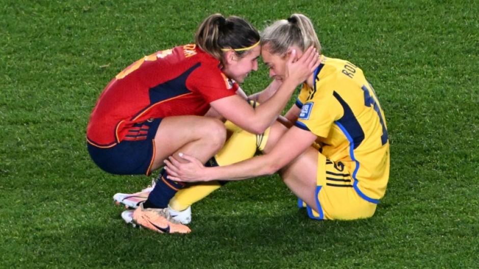 Sweden's forward Fridolina Rolfo (R) is consoled by Spain's Mariona Caldentey 