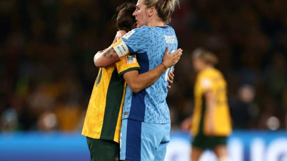 England defender Millie Bright (R) embraces Australia's forward Sam Kerr