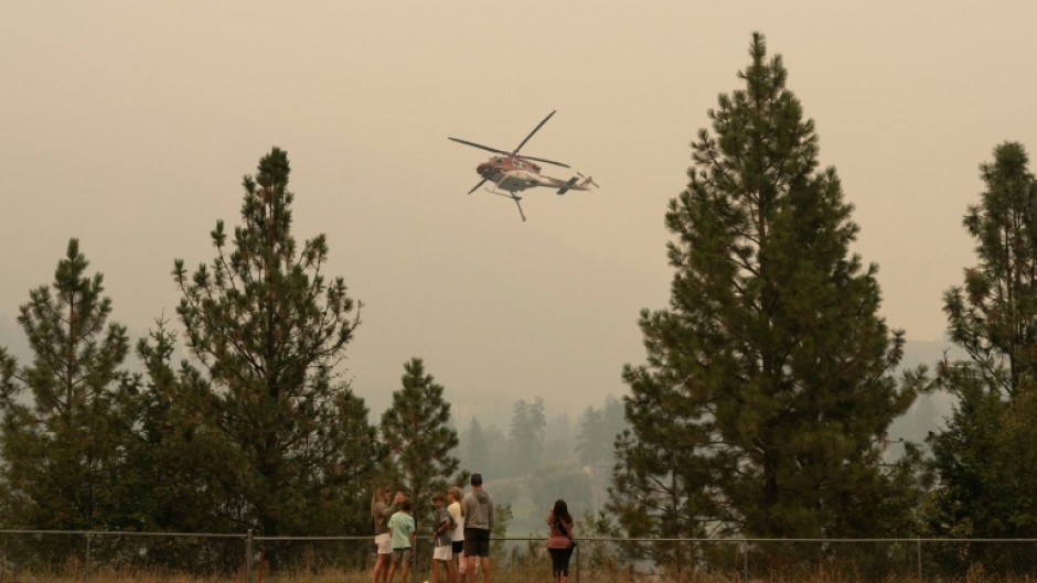 Residents of western Canada scrambled to evacuate as raging wildfires encroached on two metropolitan areas