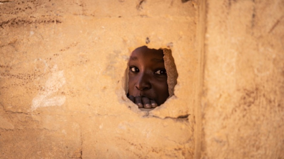 A boy looks through a hole in a wall at a school in Sakoira, in Niger's jihadist-hit Tillaberi region